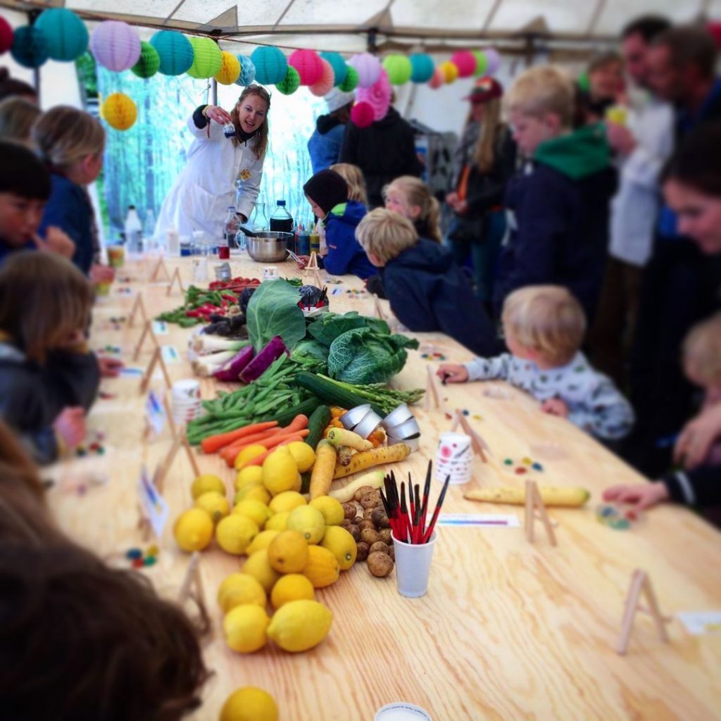 Tisch mit Essen und vielen glücklichen Kindern und Erwachsenen