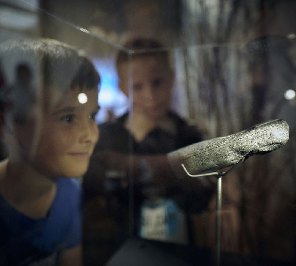Children look at objects in the Lola exhibition
