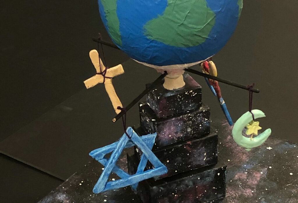 Globe with symbols in the form of a cross, star of David and crescent moon