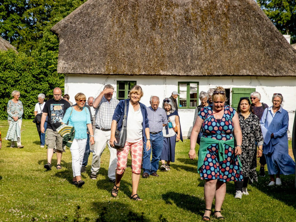 Museumsgæster på omvisning på Maribos frilandsmuseum De Gamle Huse.