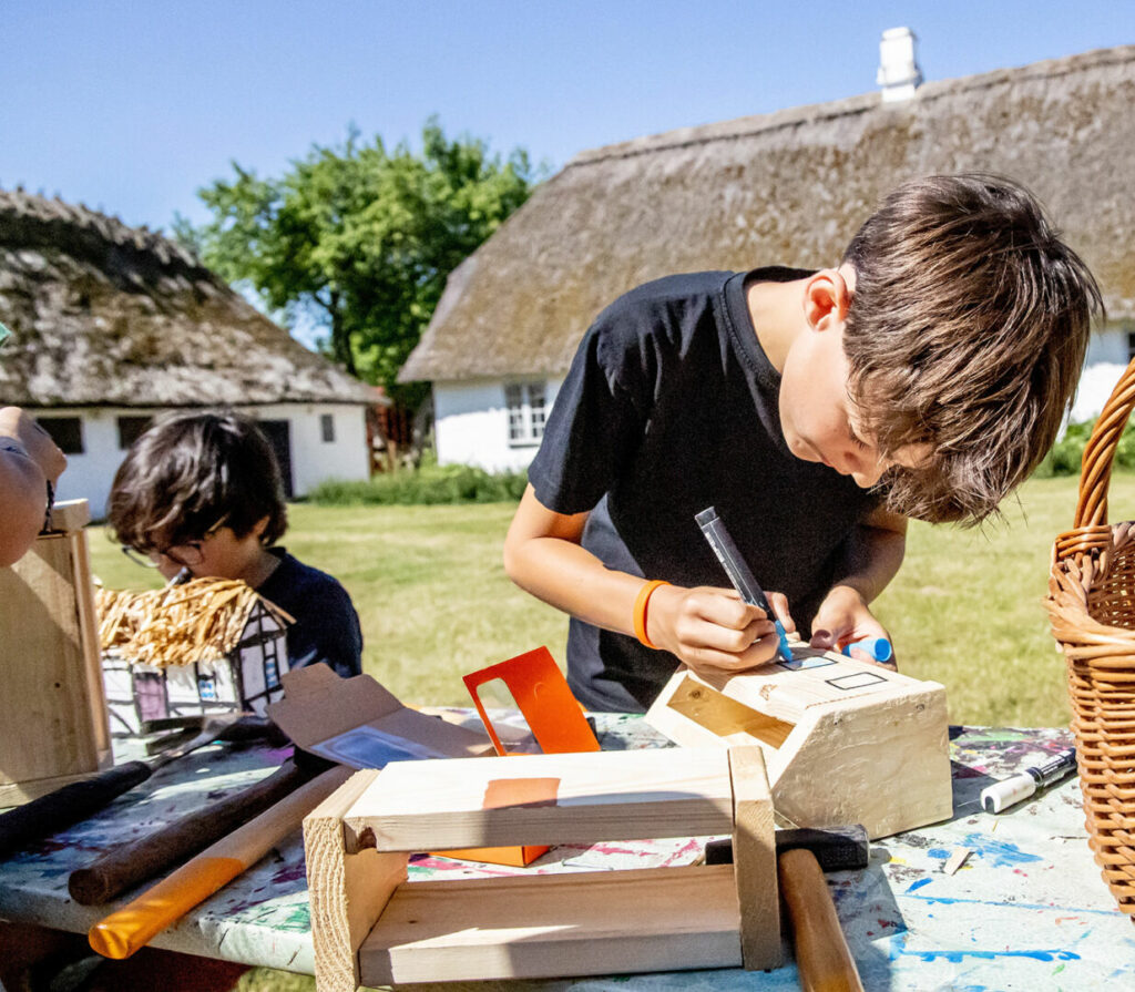 Børn i gang med at bygge modelhuse på Maribos frilandsmuseum De Gamle Huse.