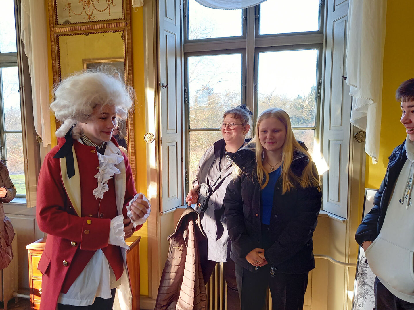 Junge Leute besuchen das Reventlow-Museet Pederstrup, wo sie Menschen in der Tracht der Zeit treffen.