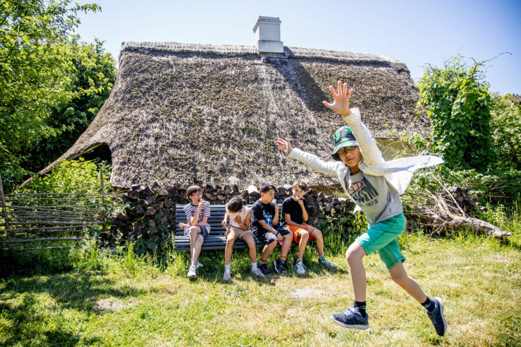 Kinder spielen zwischen den alten Häusern im Freilichtmuseum in Maribo