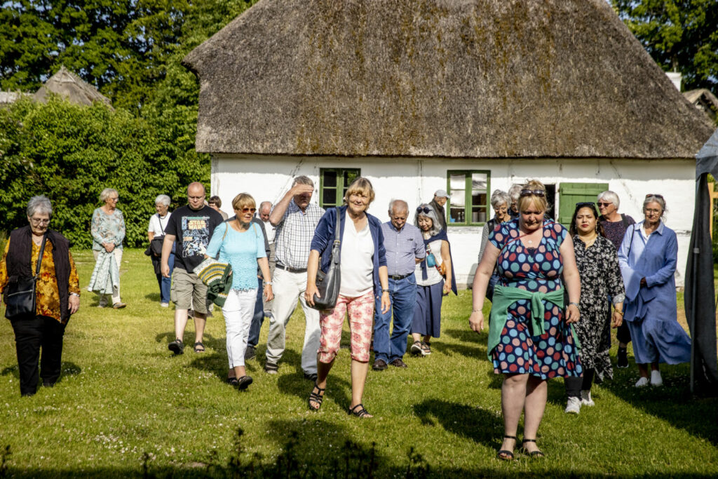 Glade gæster på rundvisning en sommerdag på Maribos frilandsmuseum De Gamle Huse.
