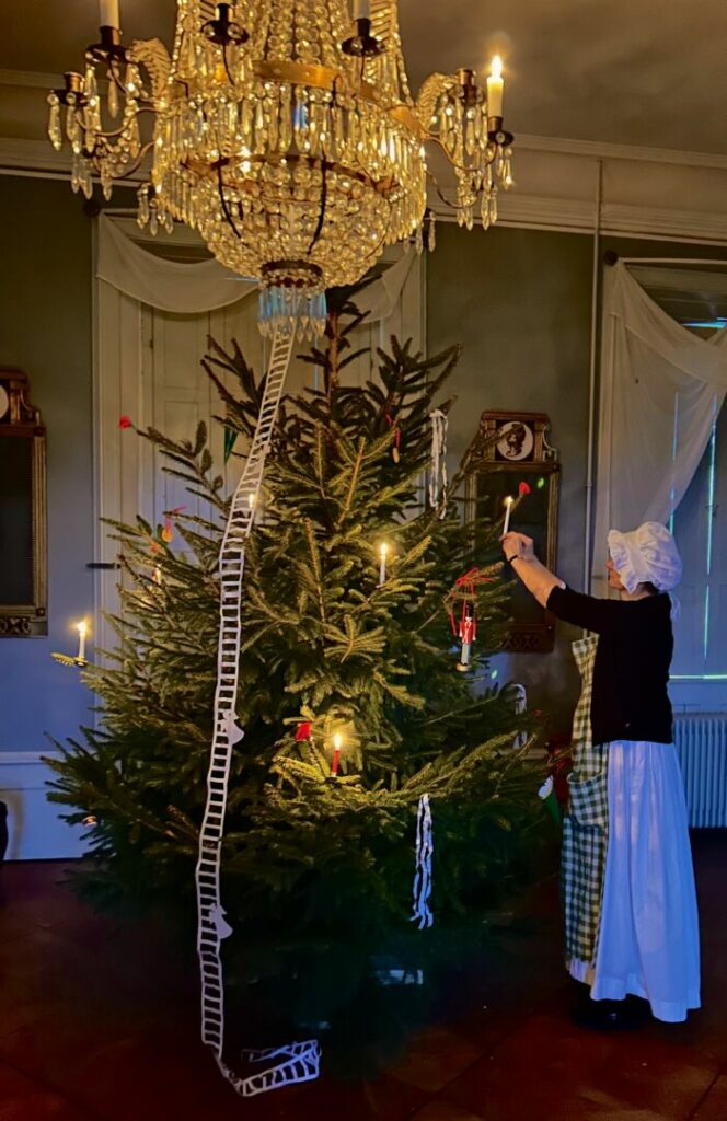 Tjenestepigen pynter juletræ i en af Pederstrups stuer.