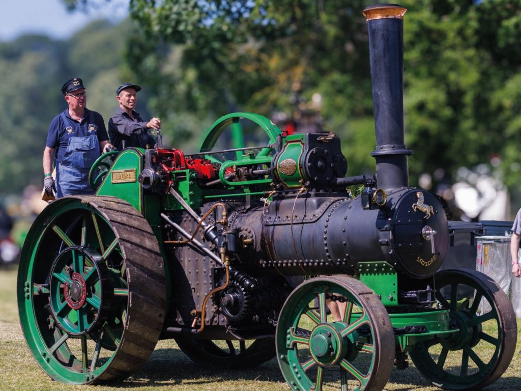 Grøn dampmaskine med to passagerer